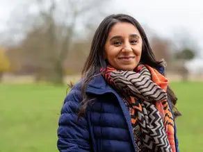 Blue puffer jacket with geometric orange and white scarf in Are You Just Pretending? article