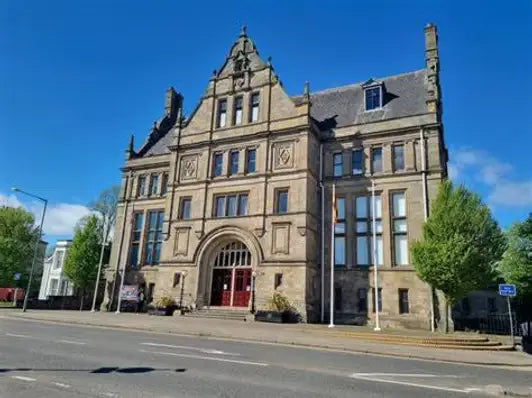 Ornate brown stone building with red doors in PSN Accreditation