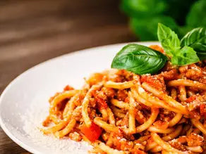 Classic spaghetti bolognese with basil and parmesan on plate