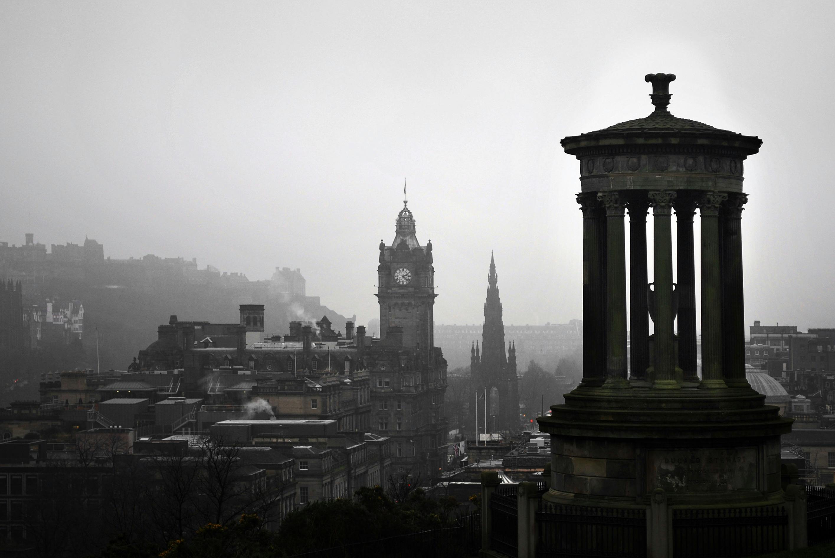 Cityscape with a clock tower and a monument on a foggy day