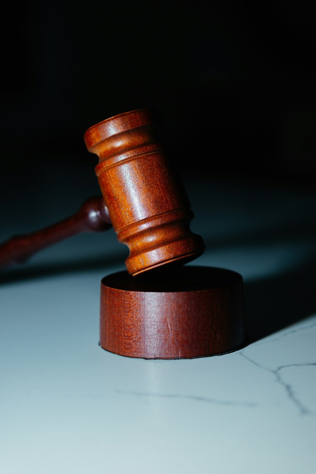 Wooden judge's gavel striking a sound block against a dark background, representing programme governance, oversight authority, and PMRO compliance assessment